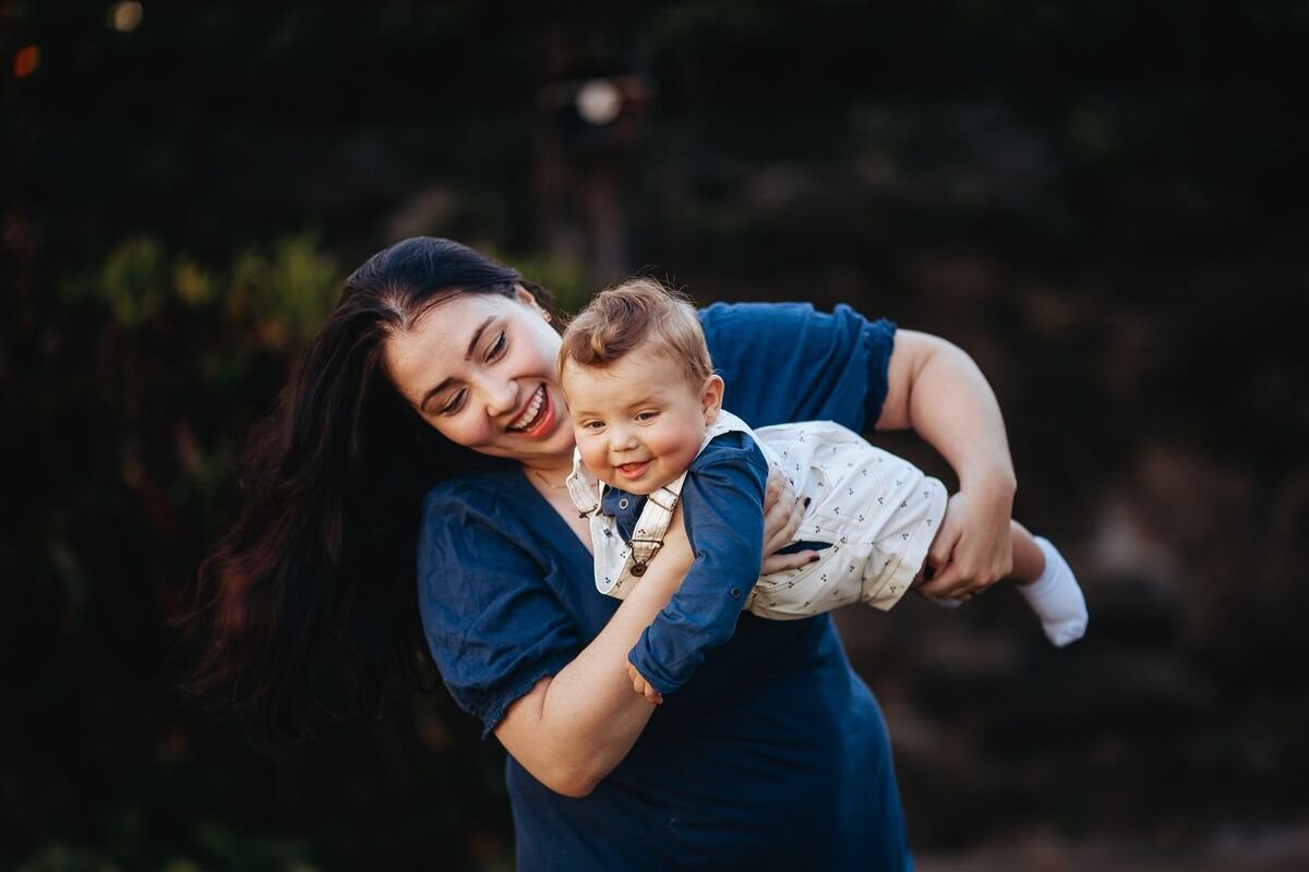 Mãe sorrindo segurando o bebê no colo